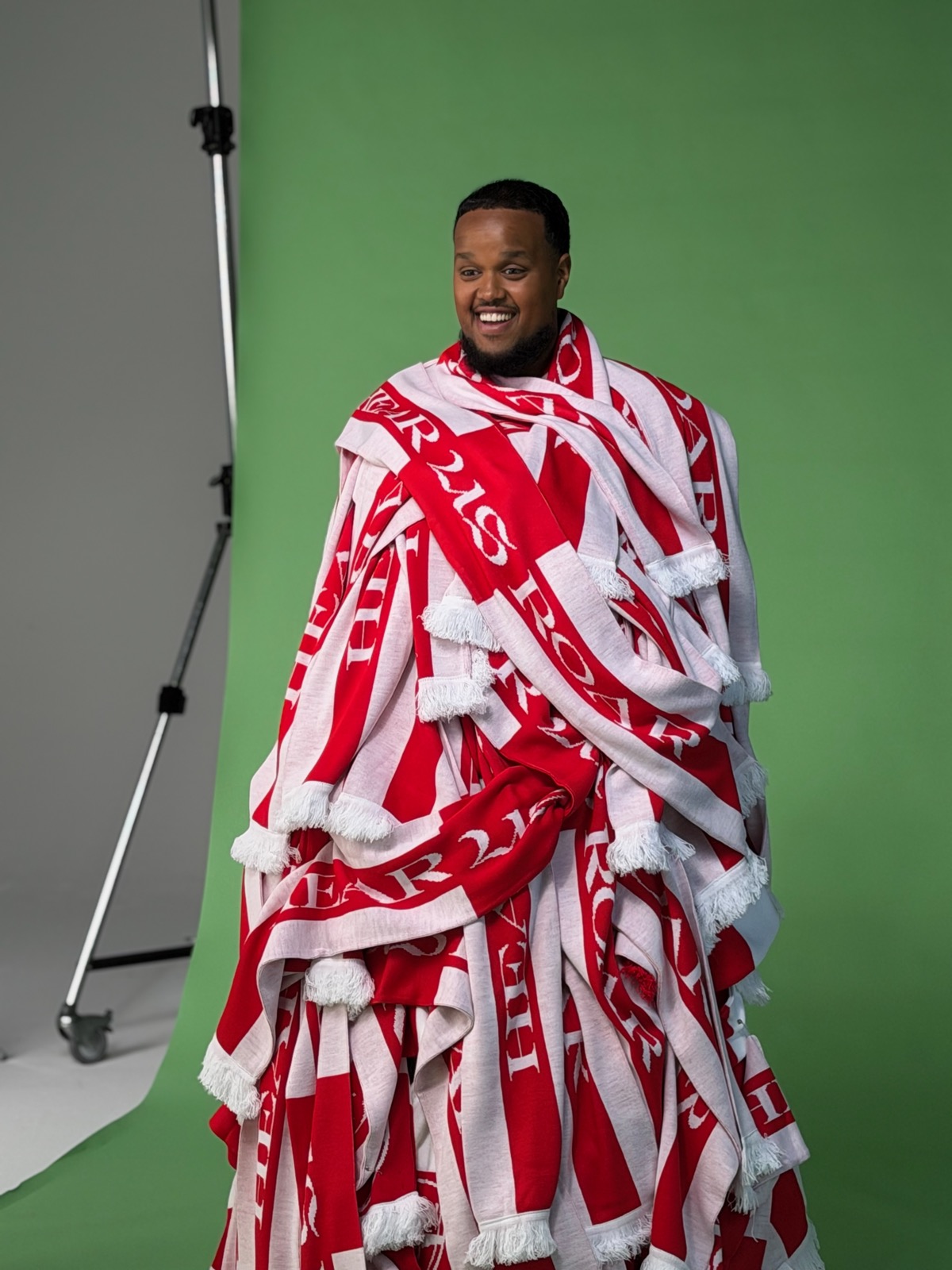 Chunkz smiling on set while covered in the campaign scarves
